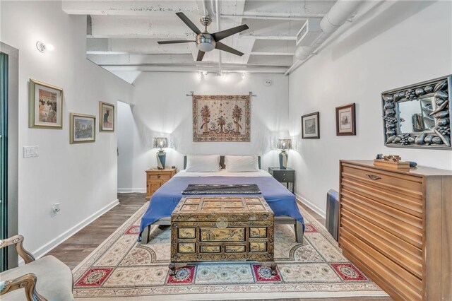 bedroom featuring hardwood / wood-style floors, lofted ceiling with beams, track lighting, and ceiling fan