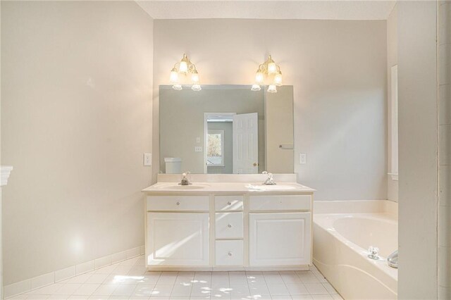 bathroom with tile patterned floors, a washtub, and vanity