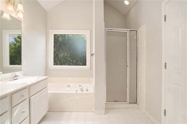 bathroom with vanity, shower with separate bathtub, and vaulted ceiling