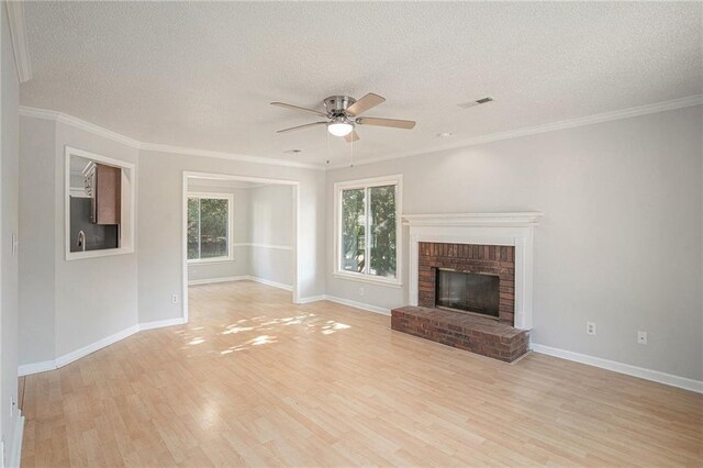 unfurnished living room with a wealth of natural light, light hardwood / wood-style flooring, and a textured ceiling