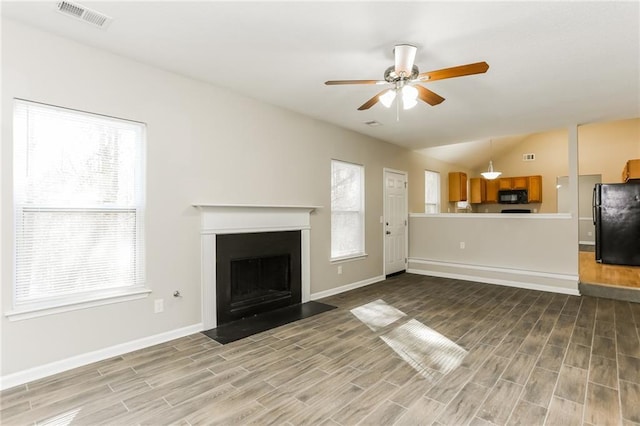 unfurnished living room featuring ceiling fan and lofted ceiling