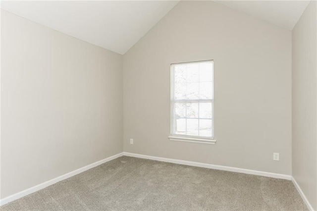 carpeted spare room with a healthy amount of sunlight and vaulted ceiling