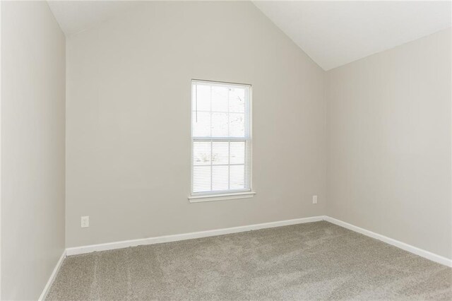 empty room featuring high vaulted ceiling and light carpet