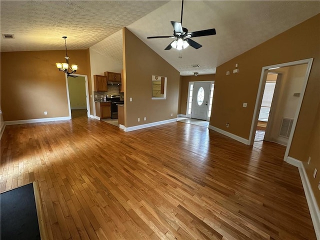 5026 Limerick Ln, Flowery Branch, GA 30542 - unfurnished living room with lofted ceiling, light wood-type flooring, a chandelier, and a ceiling fan