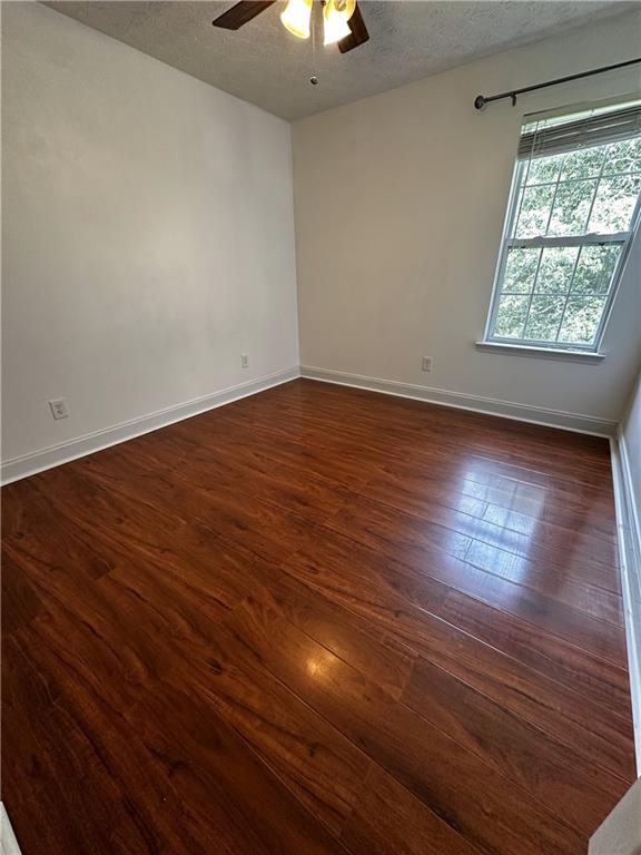 5026 Limerick Ln, Flowery Branch, GA 30542 - spare room featuring a ceiling fan, a textured ceiling, and dark wood-style floors