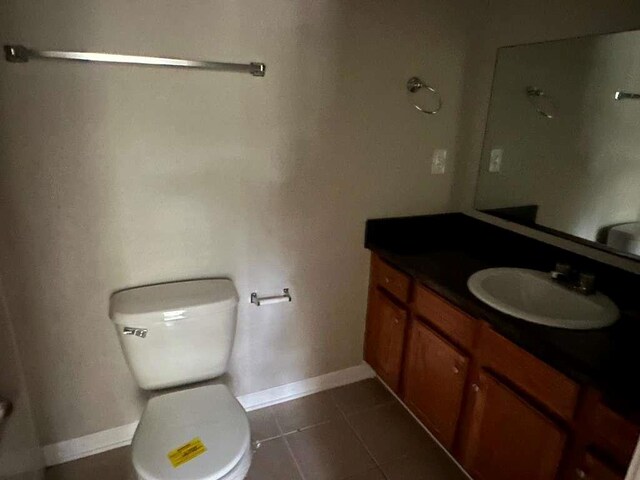 bathroom with tile patterned flooring, vanity, and toilet