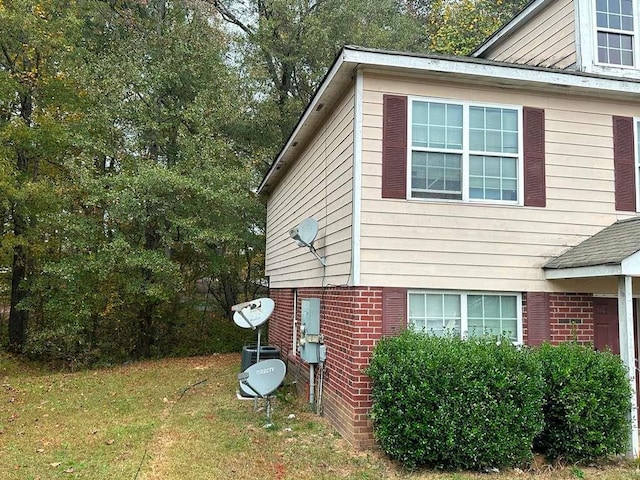 view of side of home with a yard