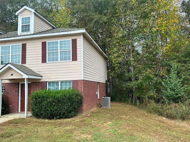 view of home's exterior with a lawn and central AC unit