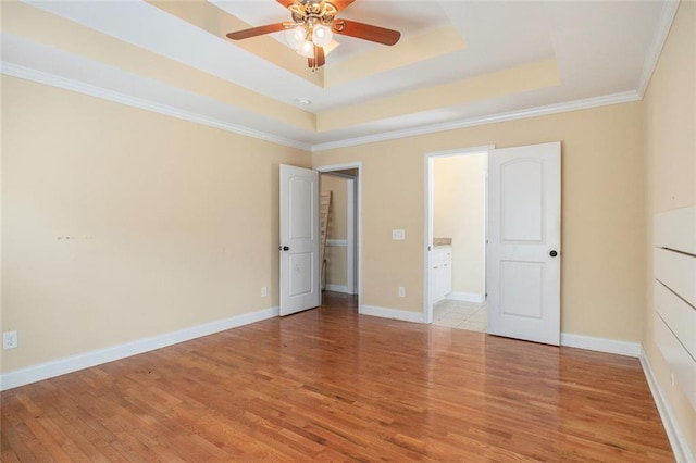 208 Stonington Dr, Mount Airy, GA 30563 - unfurnished bedroom featuring a tray ceiling, light wood-style floors, crown molding, and baseboards
