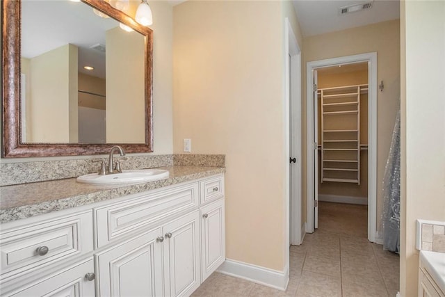 208 Stonington Dr, Mount Airy, GA 30563 - bathroom featuring tile patterned flooring, baseboards, vanity, and a spacious closet