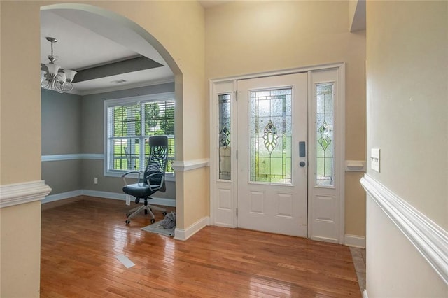 208 Stonington Dr, Mount Airy, GA 30563 - foyer featuring arched walkways, a chandelier, hardwood / wood-style flooring, and baseboards