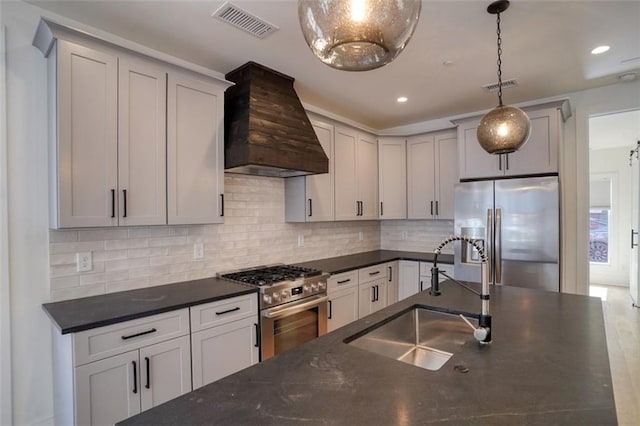 kitchen featuring a sink, custom range hood, visible vents, and stainless steel appliances