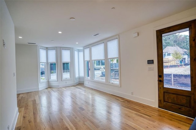 entryway featuring plenty of natural light, baseboards, and light wood finished floors