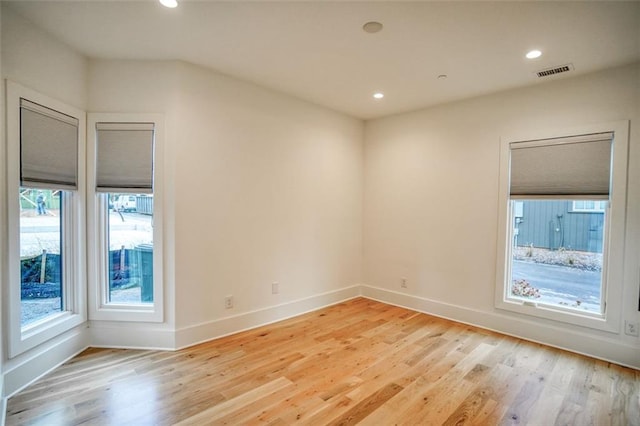 empty room with visible vents, recessed lighting, light wood-type flooring, and baseboards