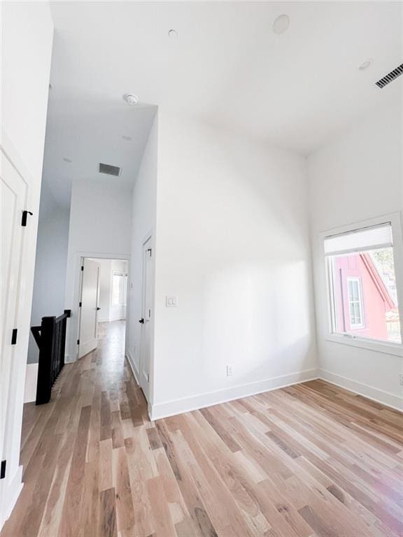 empty room featuring light wood-style flooring, baseboards, and visible vents