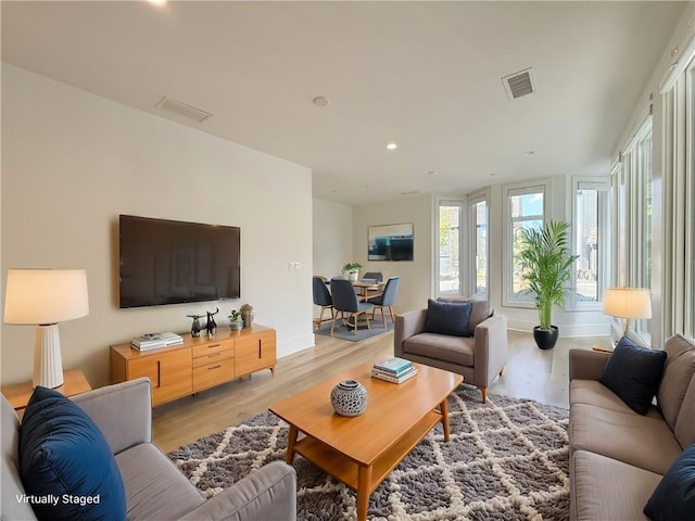 living area featuring recessed lighting, baseboards, visible vents, and light wood finished floors