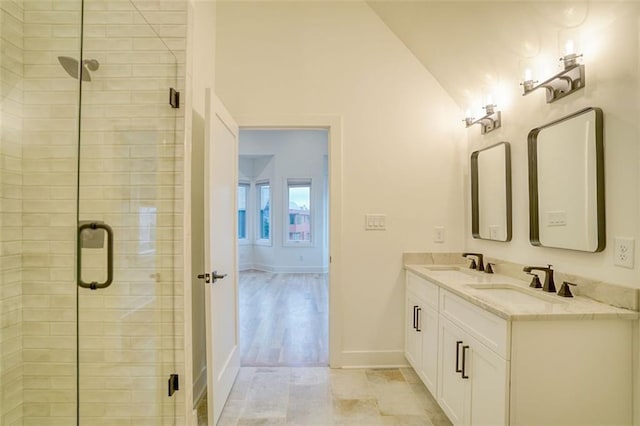 bathroom featuring a sink, lofted ceiling, and a shower stall