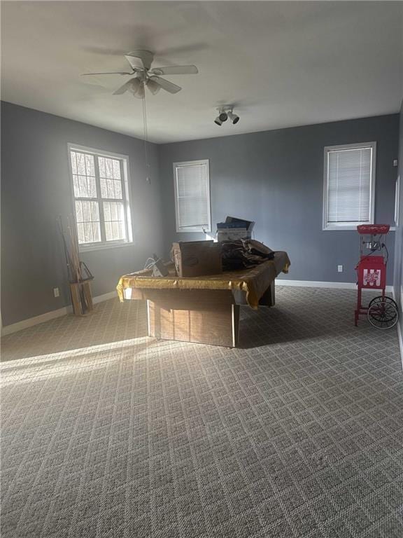 interior space with carpet flooring, a ceiling fan, and baseboards