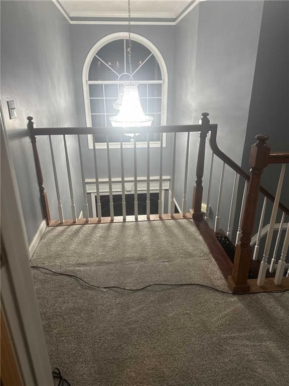 staircase with crown molding, a notable chandelier, and baseboards