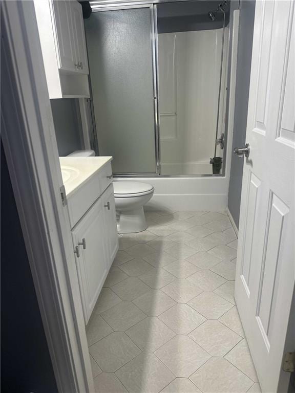 full bathroom featuring toilet, combined bath / shower with glass door, vanity, and tile patterned floors