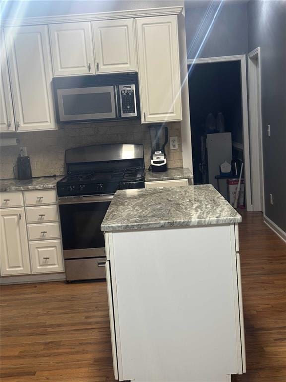 kitchen with appliances with stainless steel finishes, dark wood-type flooring, and white cabinetry