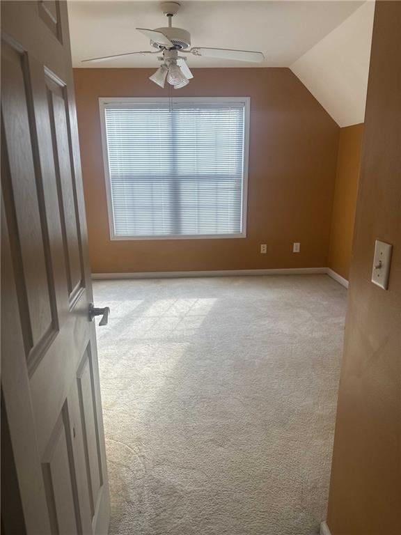 additional living space featuring ceiling fan, baseboards, vaulted ceiling, and light colored carpet