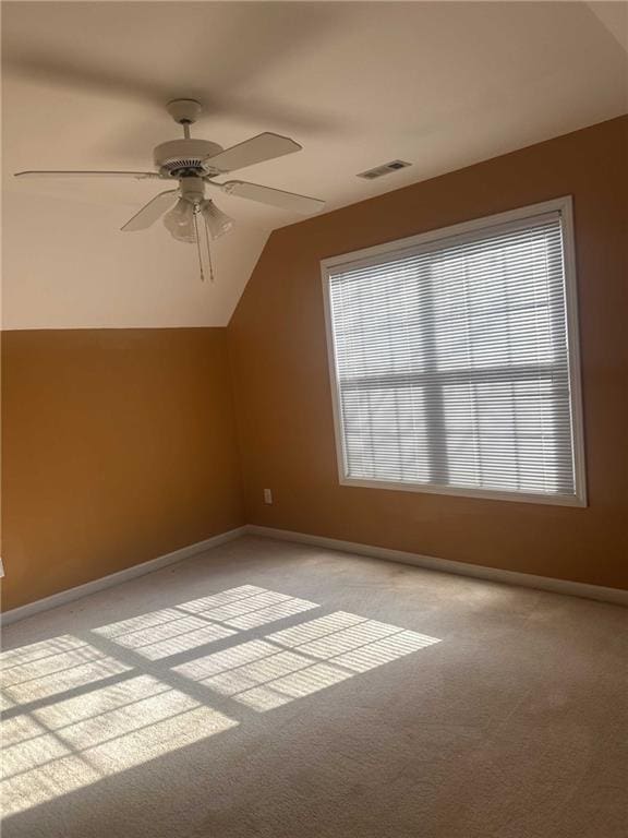 bonus room with light colored carpet, visible vents, a ceiling fan, vaulted ceiling, and baseboards