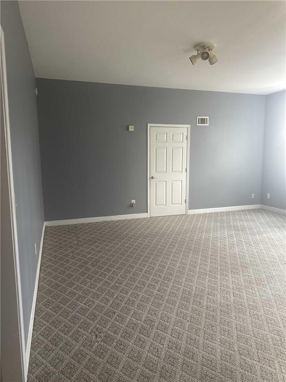 carpeted empty room with baseboards