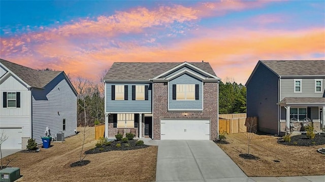 view of front of house featuring an attached garage, central air condition unit, brick siding, fence, and concrete driveway