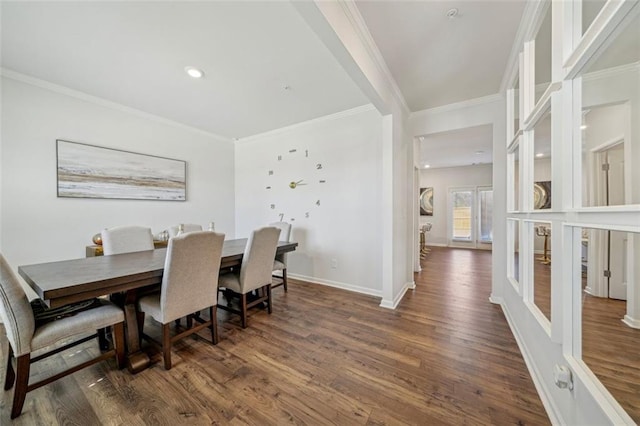 dining room with crown molding, baseboards, and wood finished floors