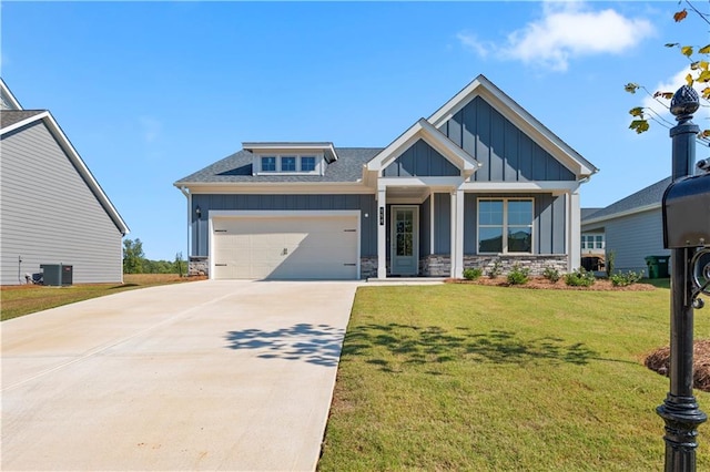 craftsman-style house with cooling unit, a garage, and a front lawn