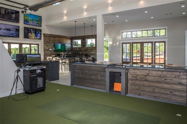 kitchen with golf simulator, french doors, a high ceiling, and a wealth of natural light