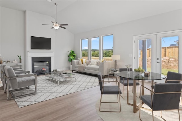 living room with french doors, high vaulted ceiling, light wood-type flooring, and ceiling fan