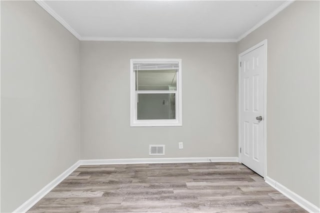 empty room featuring ornamental molding and light hardwood / wood-style floors