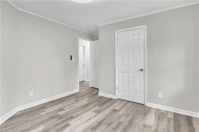 unfurnished room featuring crown molding and light wood-type flooring