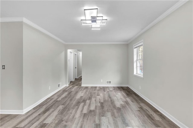 spare room with hardwood / wood-style floors and crown molding