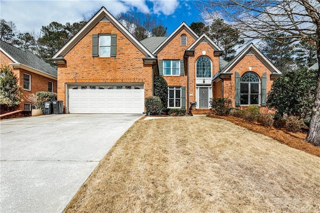 traditional home featuring a garage, concrete driveway, brick siding, and a front lawn