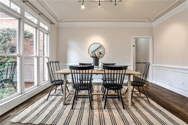 dining area with dark wood-style floors, a wainscoted wall, a wealth of natural light, and crown molding