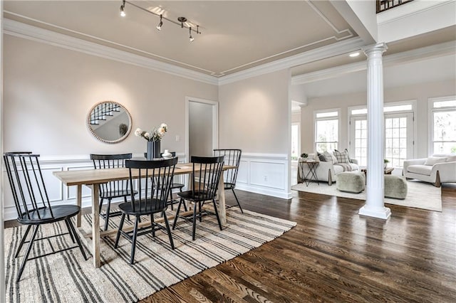 dining space with ornamental molding, wood finished floors, decorative columns, and rail lighting