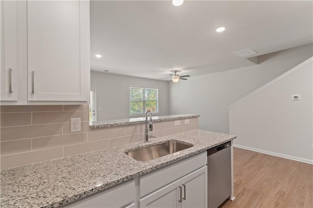 kitchen with ceiling fan, dishwasher, sink, decorative backsplash, and white cabinets