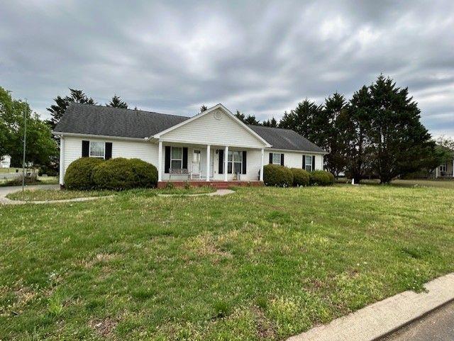 ranch-style home with a porch and a front yard