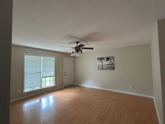 176 Elbert St, Chatsworth, GA 30705 - empty room with wood finished floors, ceiling fan, a textured ceiling, and baseboards