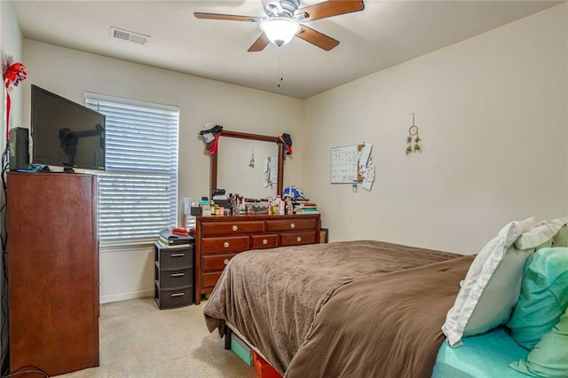 bedroom featuring baseboards, light colored carpet, visible vents, and ceiling fan