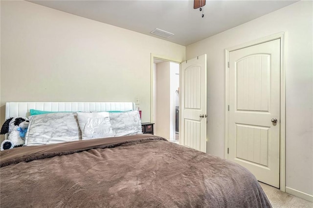 bedroom featuring ceiling fan, visible vents, and light carpet