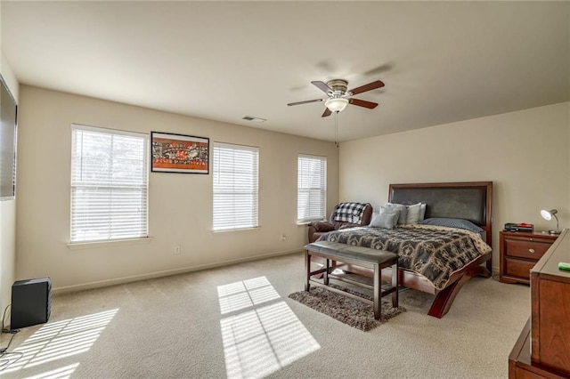 bedroom with light carpet, visible vents, a ceiling fan, and baseboards