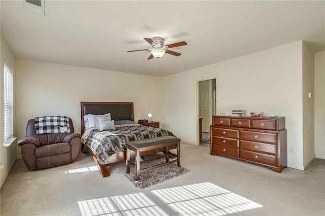 bedroom with visible vents, baseboards, light colored carpet, and ceiling fan