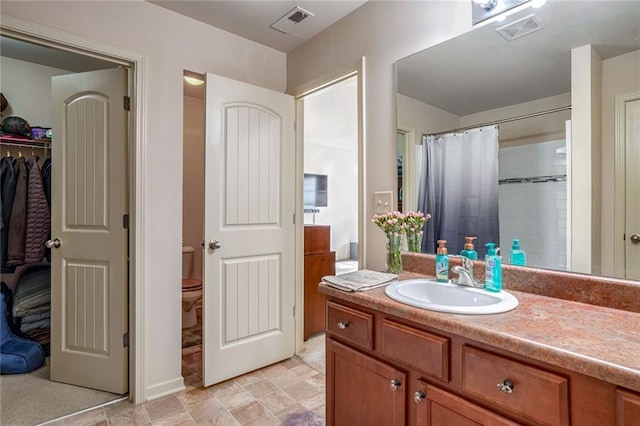 full bath with vanity, toilet, a shower with curtain, and visible vents