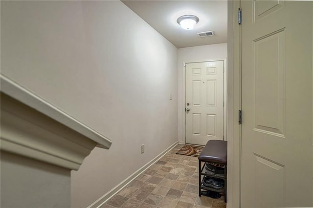 entryway with visible vents, baseboards, and stone finish floor