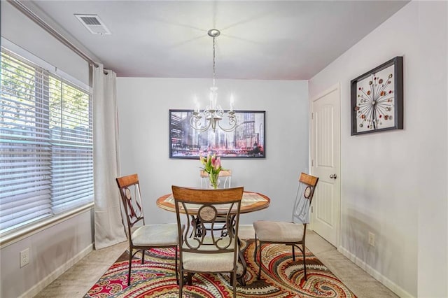 dining area featuring visible vents, baseboards, and a notable chandelier