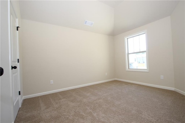 carpeted empty room with lofted ceiling